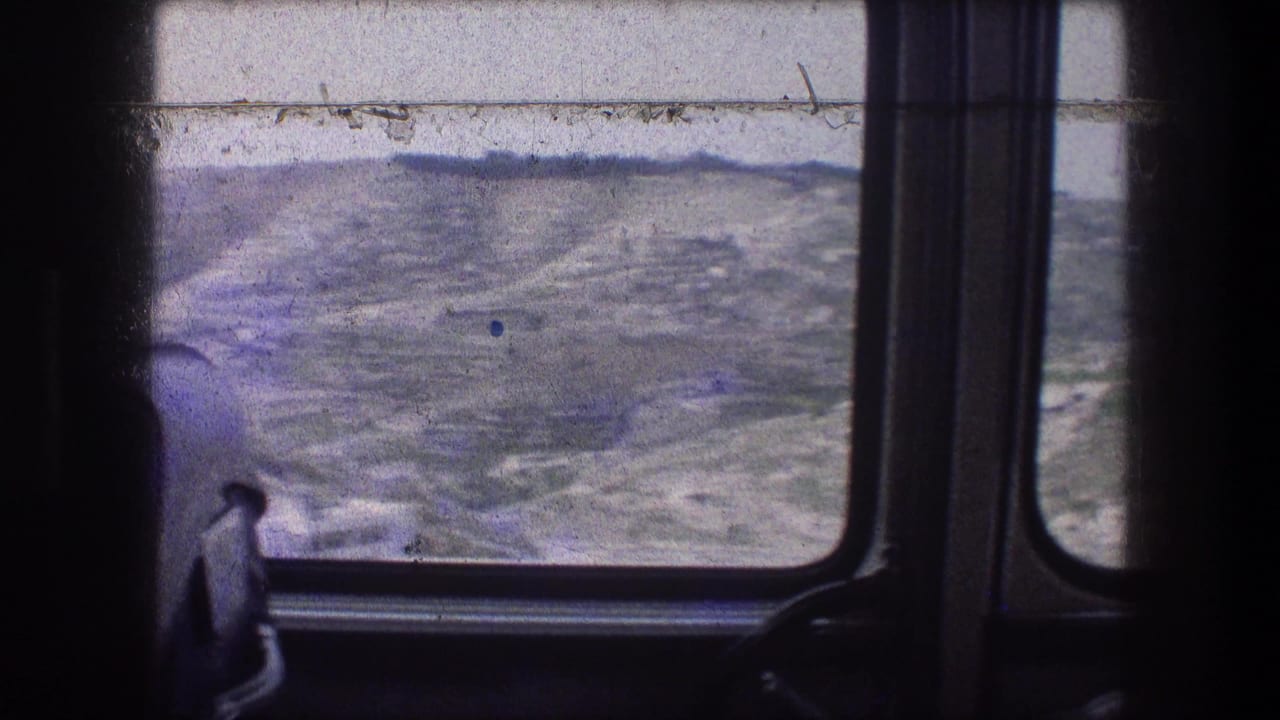 View from inside a moving vehicle toward rolling hills near Bethlehem, with dark window framing and faded 8mm color.