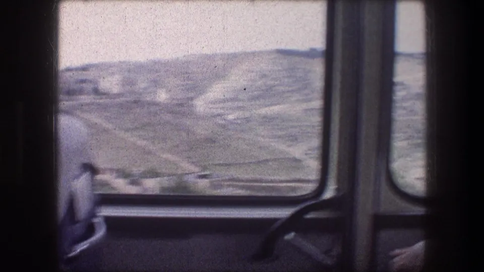 Faded 8mm view of Bethlehem-area hills through a vehicle window, with the seat and window frame visible in the foreground.