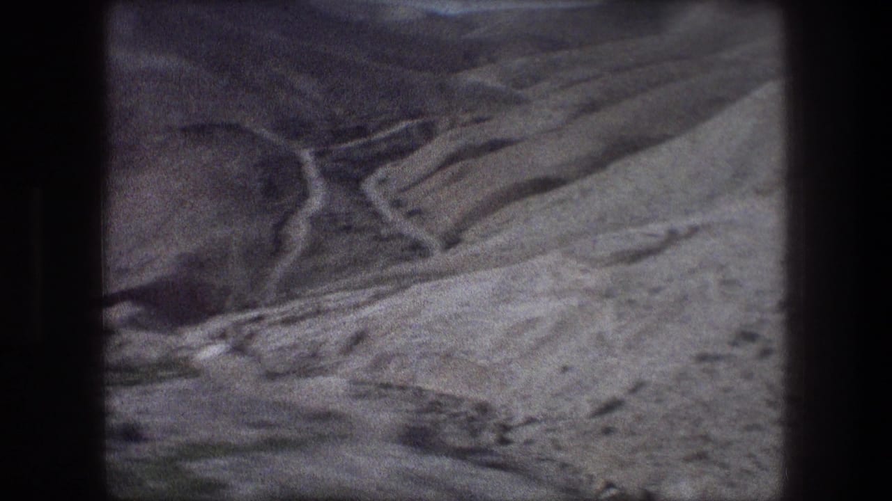 Dry hills and a winding ravine seen through dark 8mm frame borders.