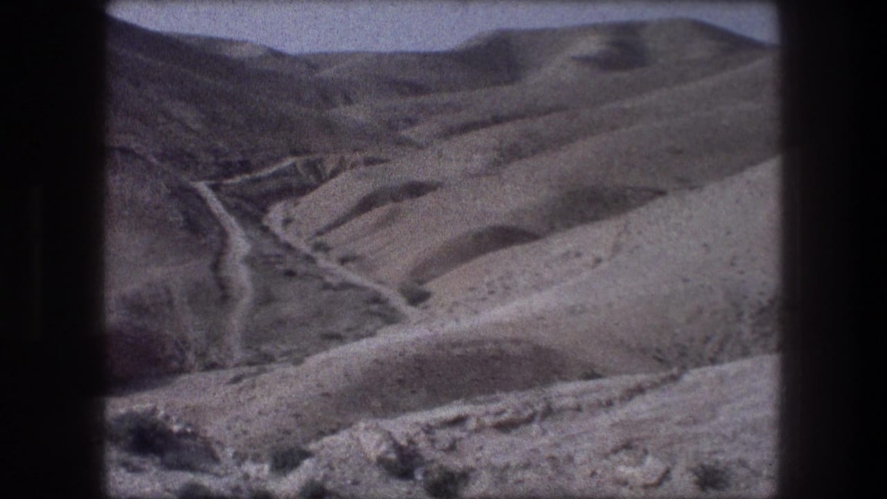1976 8mm view near Bethlehem showing dry hills, sparse vegetation, and a winding road through open terrain.