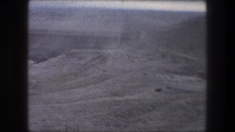 1976 8mm car-window view near Bethlehem, Israel, with dry hills and faint route lines in the terrain.