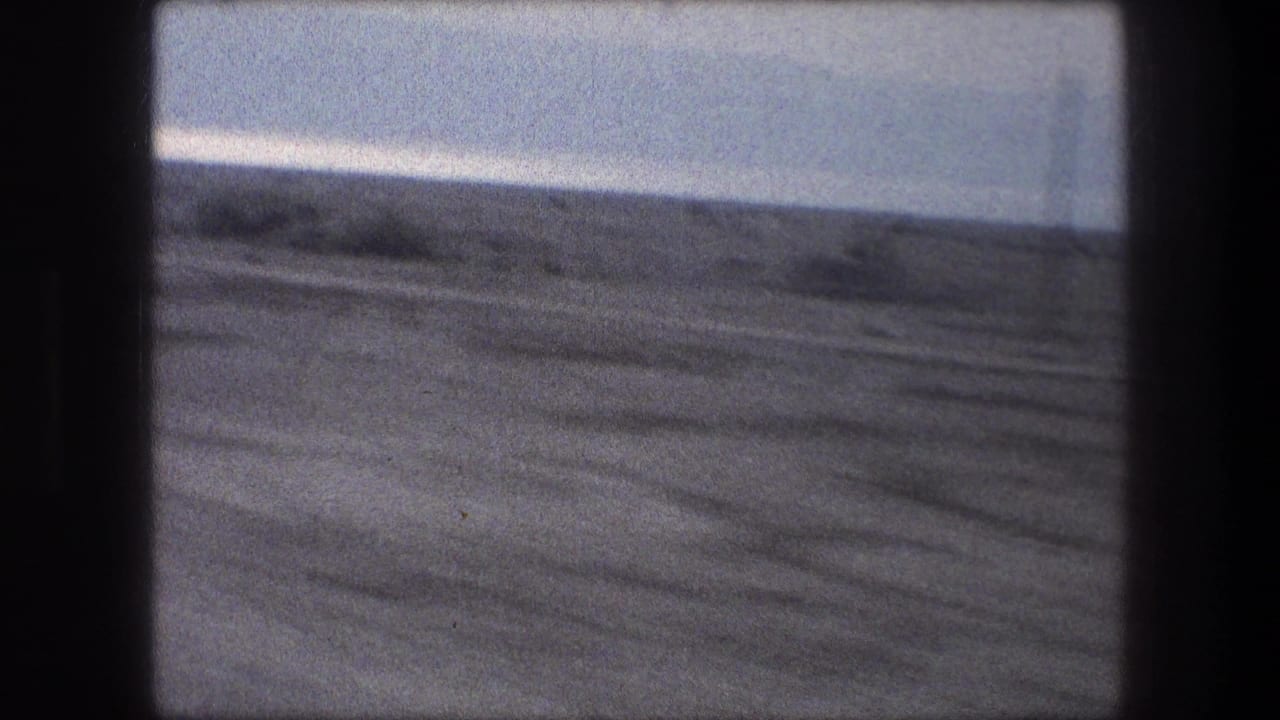 Muted 8mm frame of open land near Bethlehem, filmed from inside a moving car in 1976.