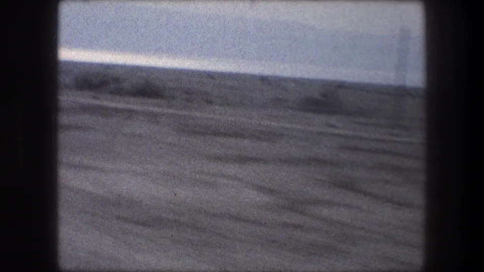 Muted 8mm frame of open land near Bethlehem, filmed from inside a moving car in 1976.