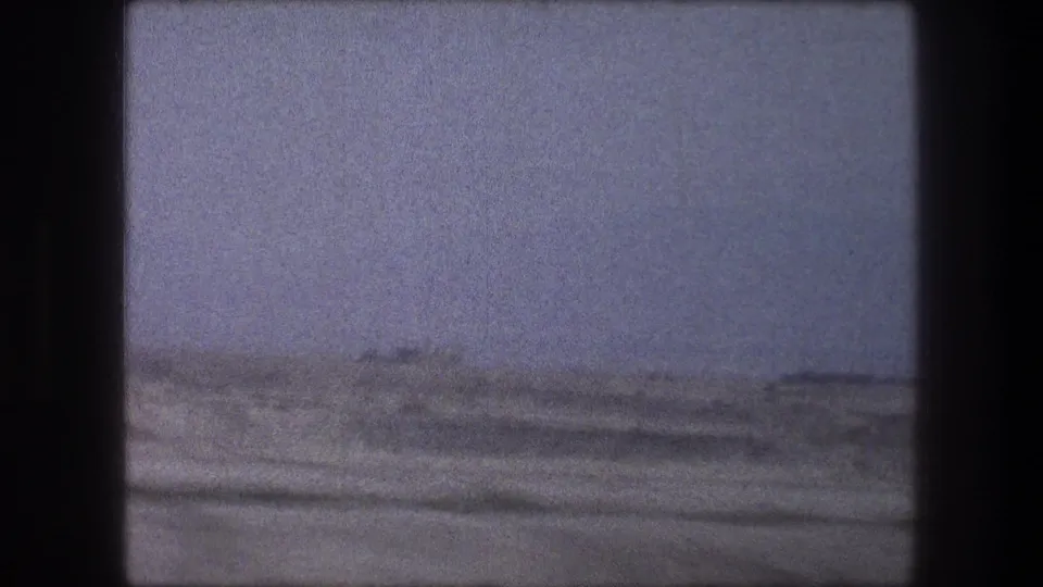 1976 8mm frame near Bethlehem, Israel, showing a muted snowy landscape through the dark framing of a moving vehicle.