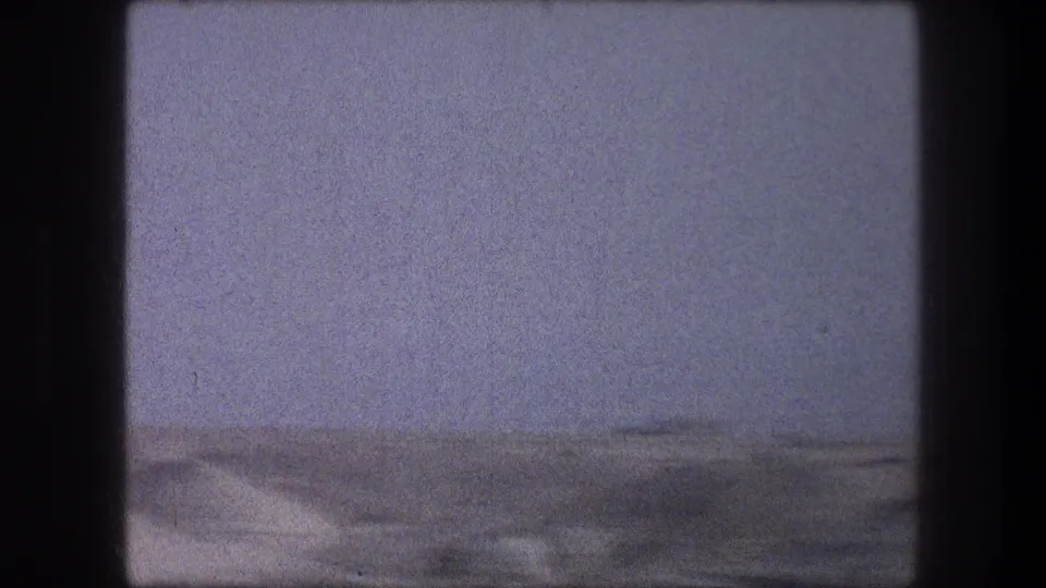 1976 8mm Bethlehem-area travel frame showing a soft, hazy desert horizon and open sandy ground.