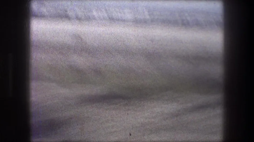 Soft 8mm view of the Bethlehem arid landscape, with pale sand and distant low hills after the camera pans away from the camels.