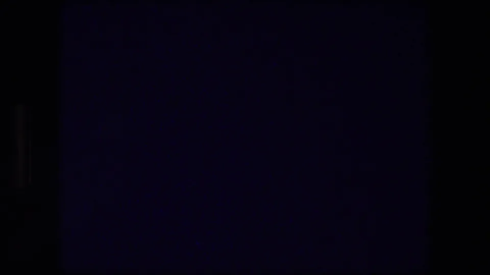 Dark opening frame from 8mm footage, with heavy underexposure, bluish cast, and little visible subject detail.