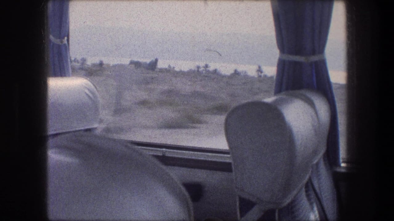 Vehicle interior with blue curtain, seat back, and dry landscape seen through the window.