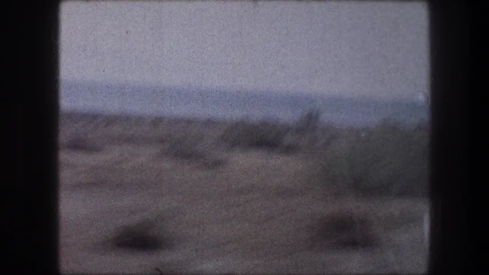 1976 8mm travel frame showing sandy desert brush through a vehicle window in the Bethlehem, Israel metadata context.