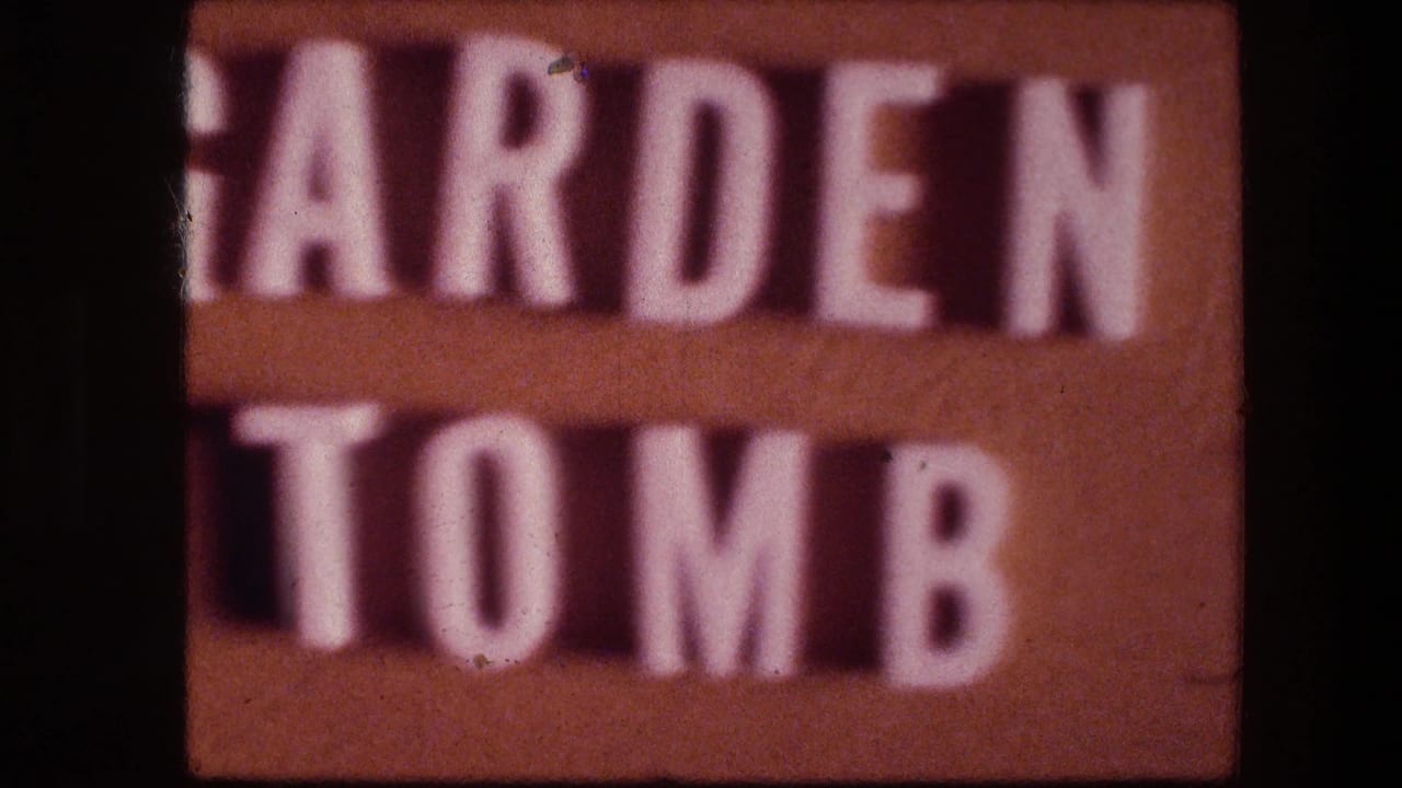 Close-up of partial raised white letters on a brown sign surface.