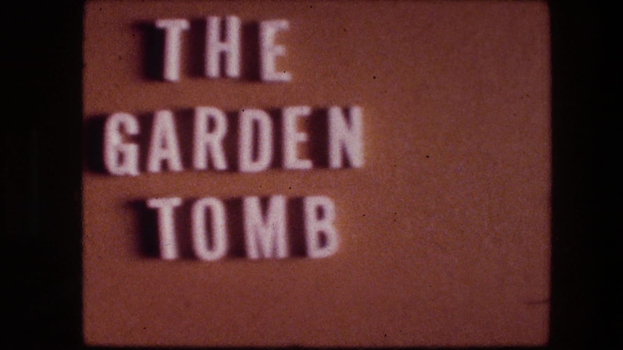 Raised white letters spell THE GARDEN TOMB on a brown sign.