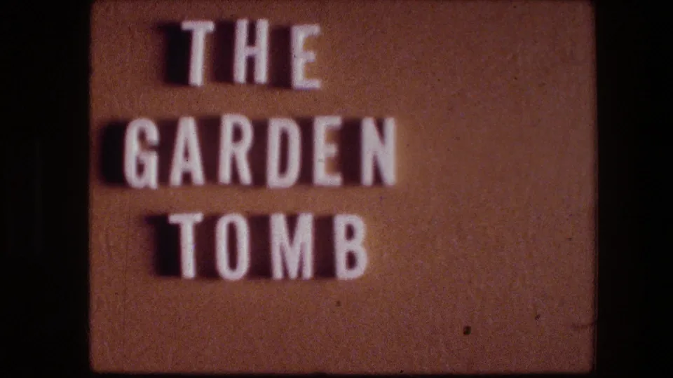 The zoomed-out view centers the Garden Tomb sign, with raised white letters and warm faded 8mm color.