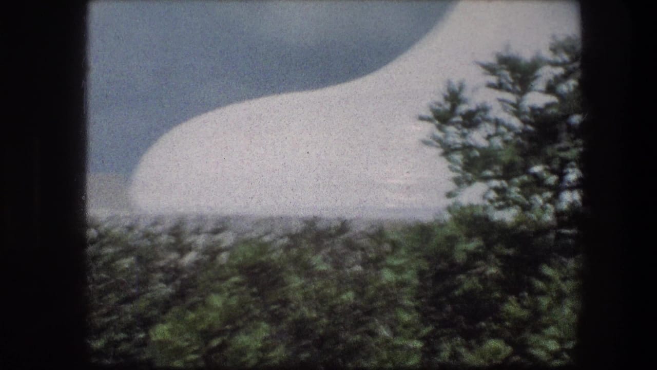 White domed form seen through trees and stone walls at the Garden Tomb in Jerusalem on 8mm film.