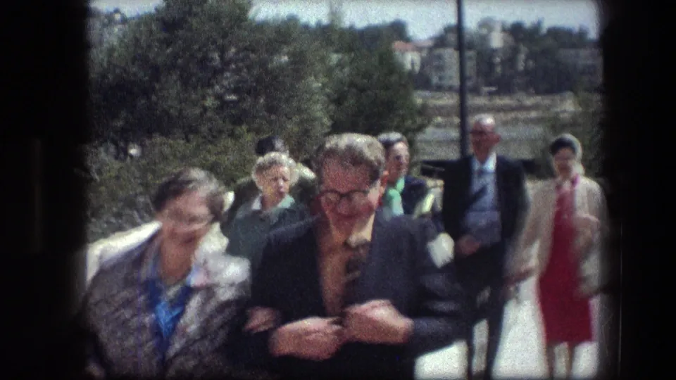 Tourists continue along the Garden Tomb path in Jerusalem, filmed in soft 1970s 8mm color.