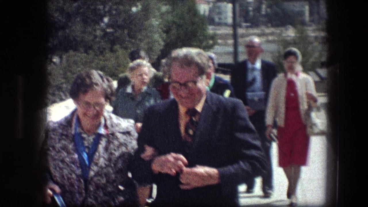 At the Garden Tomb in Jerusalem, tourists in mid-1970s attire walk toward the camera along an outdoor path.