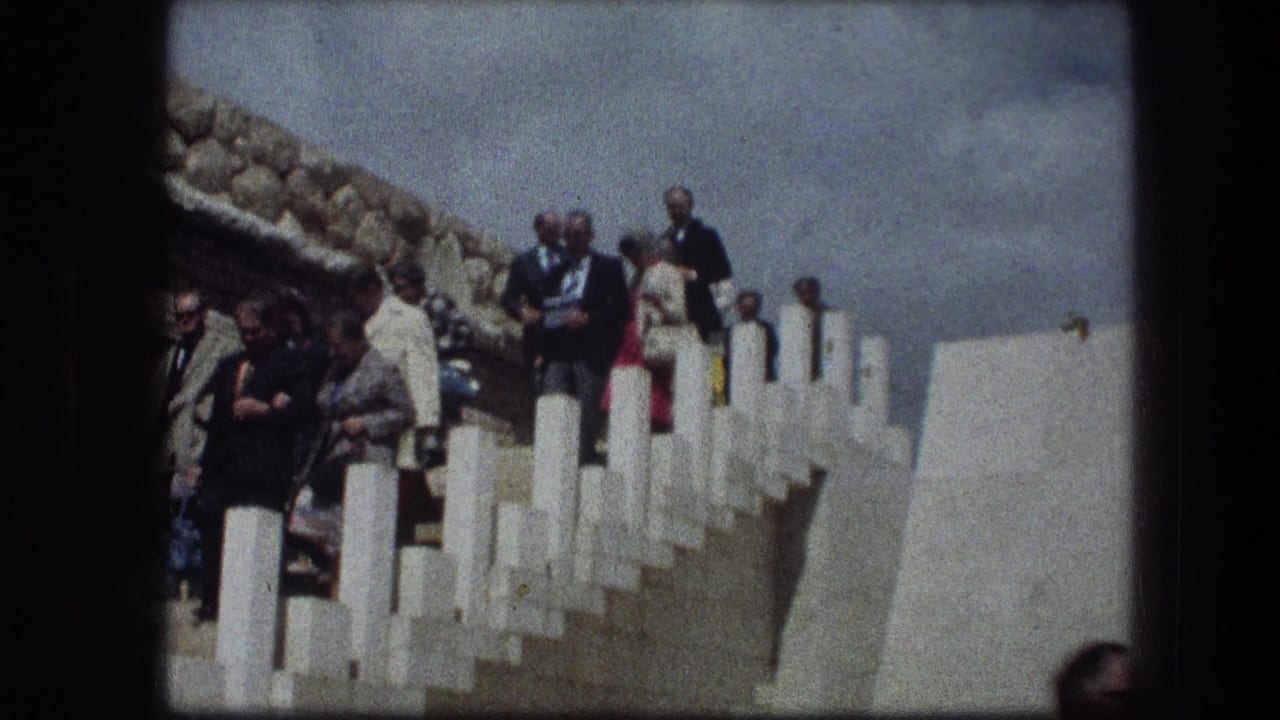 Older visitors at the Garden Tomb in Jerusalem descend the white-railed stone steps under bright daylight.