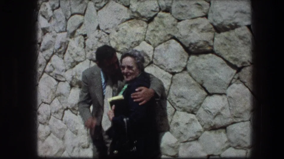 Near the end of the clip, the man leans toward the older woman while she smiles at the camera at the Jerusalem Garden Tomb.