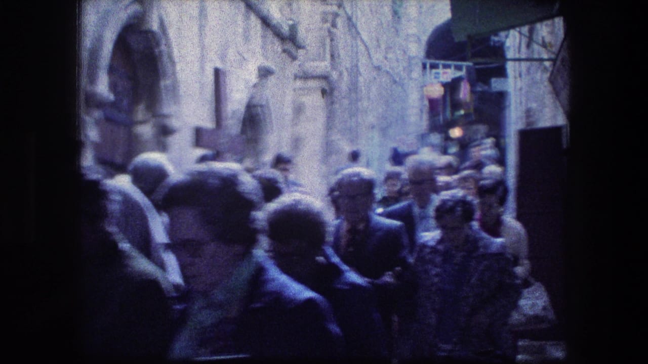 1976 8mm view near the Garden Tomb in Jerusalem, showing pedestrians in a crowded stone alley with soft blue-tinted film color.