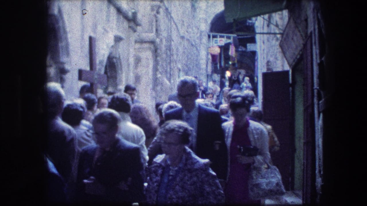 Crowded Jerusalem stone alley near the Garden Tomb, with tourists and pedestrians walking beneath awnings in a 1976 home-movie frame.