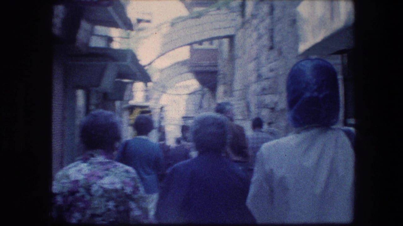 1976 8mm Jerusalem travel footage showing tourists from behind in a crowded stone alley beneath overhead arches.