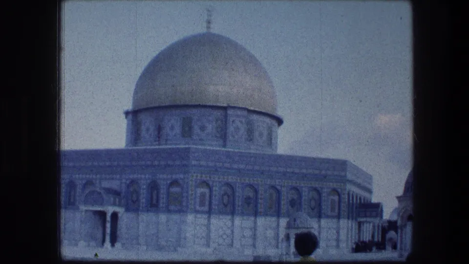 1976 8mm view of the Dome of the Rock in Jerusalem, with blue tilework and a quiet courtyard visible.