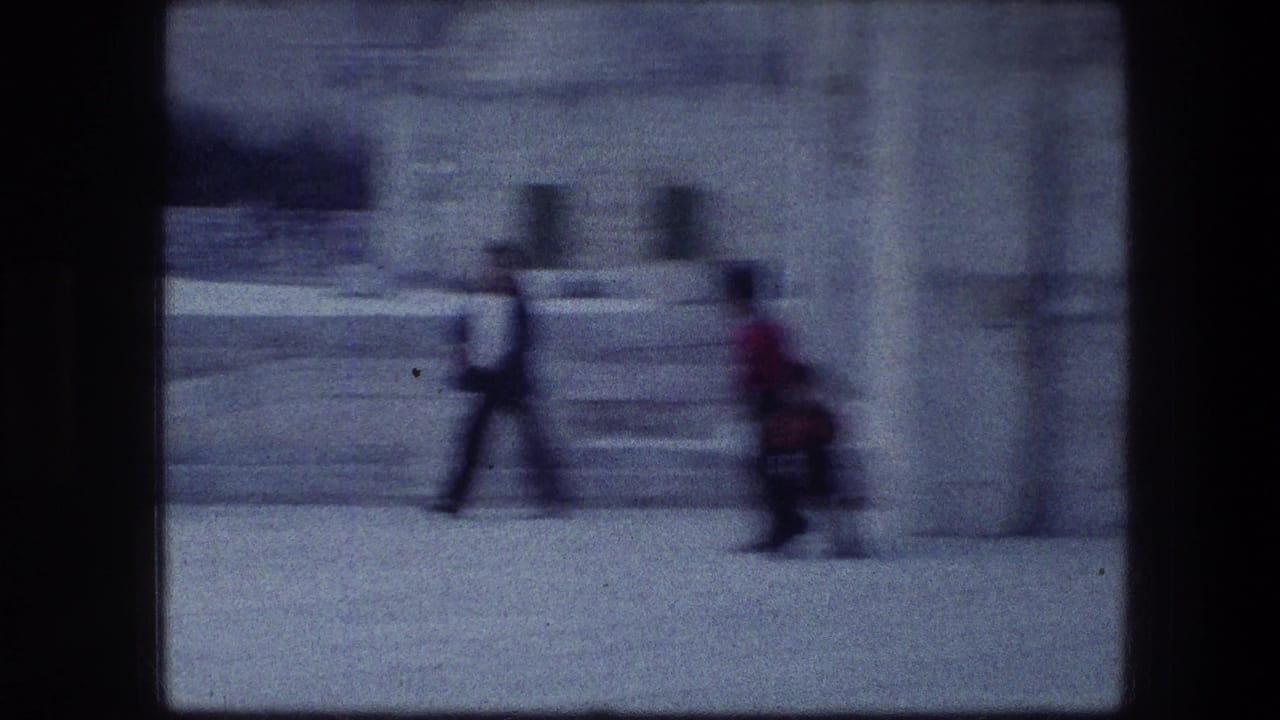 Blurred pedestrians walking beside pale stone steps and walls.