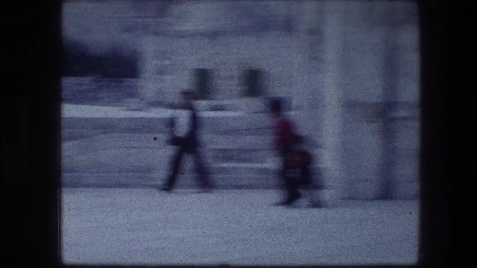 1976 8mm Jerusalem visitor footage showing blurred people walking near pale stone steps and masonry.