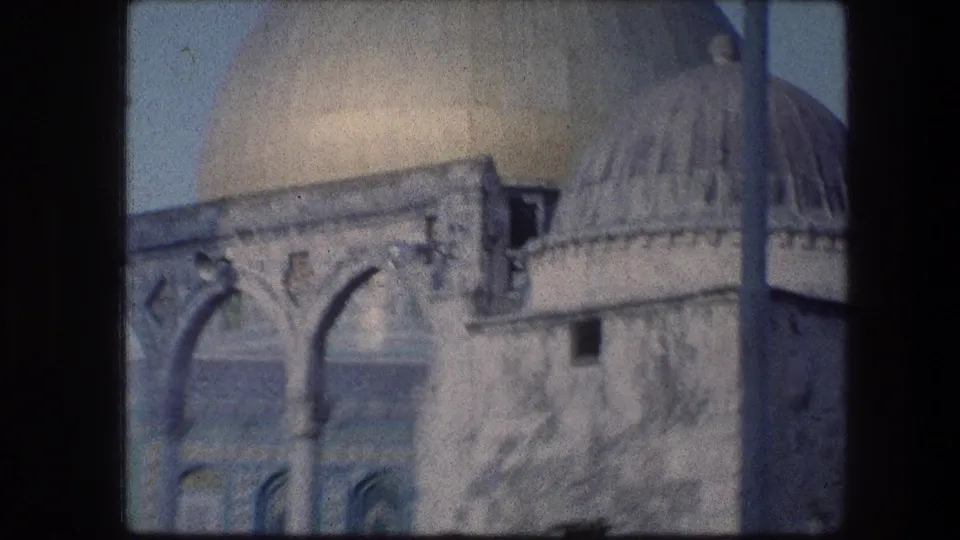 Jerusalem religious landmark detail with a domed roof, stone arches, and weathered masonry captured on faded 8mm film.