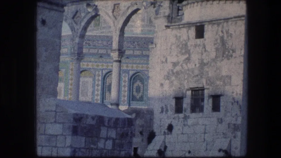 1976 home-movie frame showing arches, blue tilework, weathered stone, and a domed roof at the Jerusalem landmark.