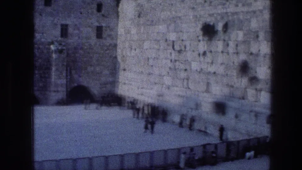1976 8mm travel footage appears to show the Western Wall in Jerusalem, with small figures gathered at its base.