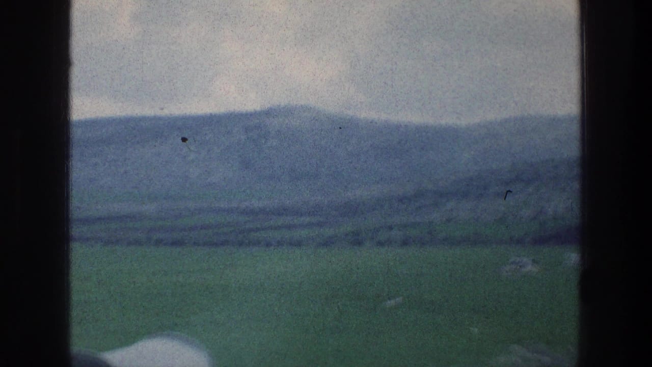Soft 8mm view of green rural hills and distant mountains through a vehicle window, consistent with the Israel travel metadata.