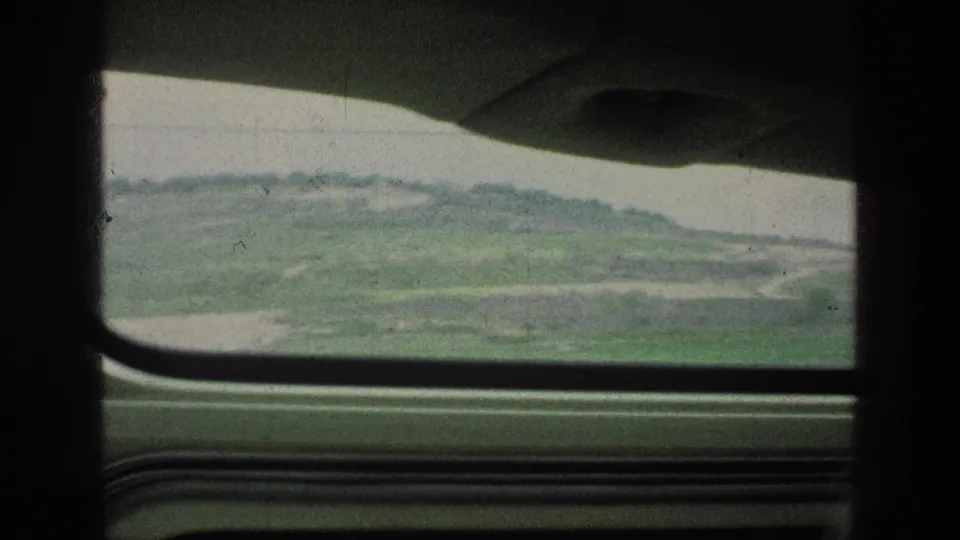1976 8mm travel frame at Jacobs Well in Jerusalem, Israel, with open hills seen through the vehicle window.