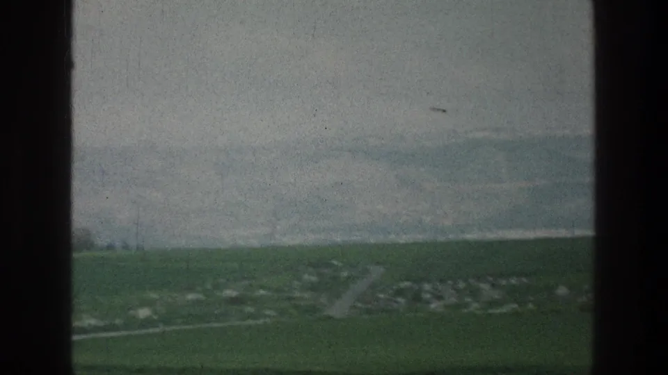 1976 8mm view near Jacobs Well, Jerusalem, showing green countryside and a faint road framed by dark window-like edges.