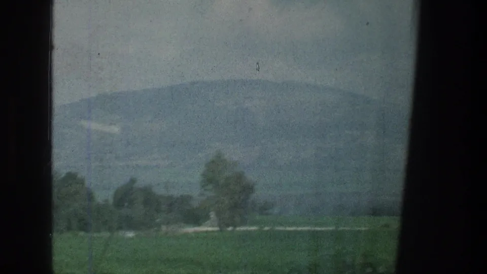 1976 8mm travel footage showing open fields, trees, and distant hills through a window near the cataloged Jacobs Well Jerusalem location.