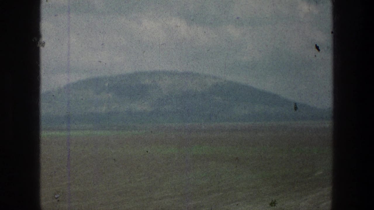 1976 8mm travel frame showing a distant hill across open fields in the Jacobs Well Jerusalem, Israel metadata location.