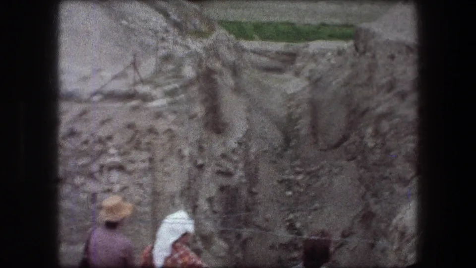 1976 Jericho 8mm view down a rocky channel with two distant people partly visible near the lower edge.