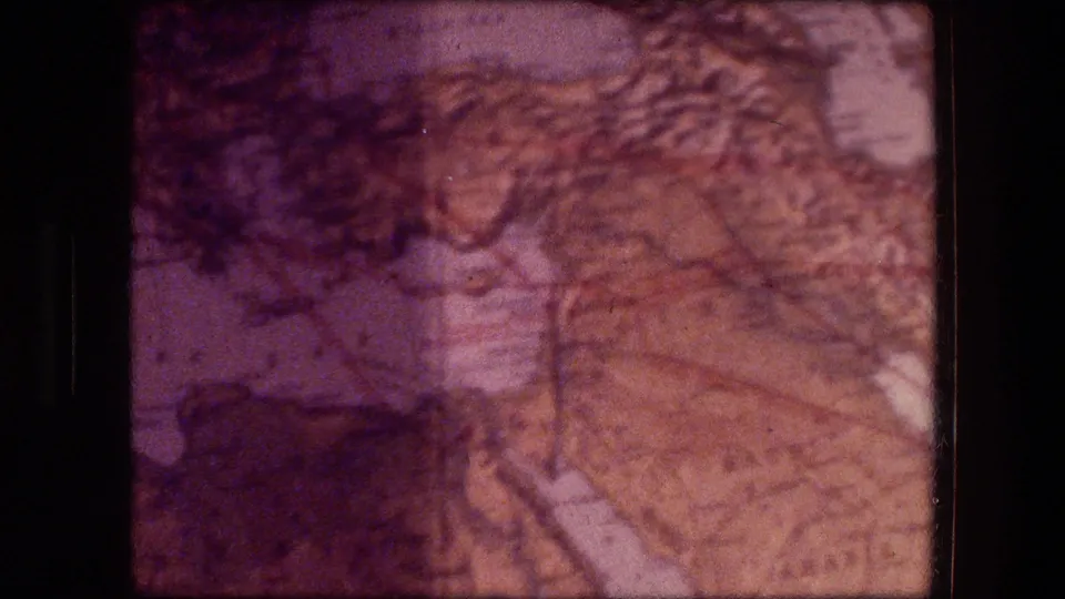 Faded 1970s 8mm Jericho clip frame showing a map-like surface with branching lines, mottled exposure, and film borders.