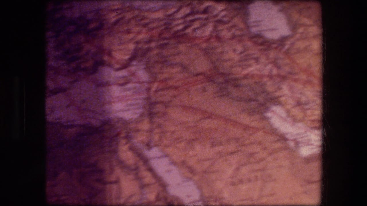Close-up of a folded printed map with faded warm color and dark film borders.