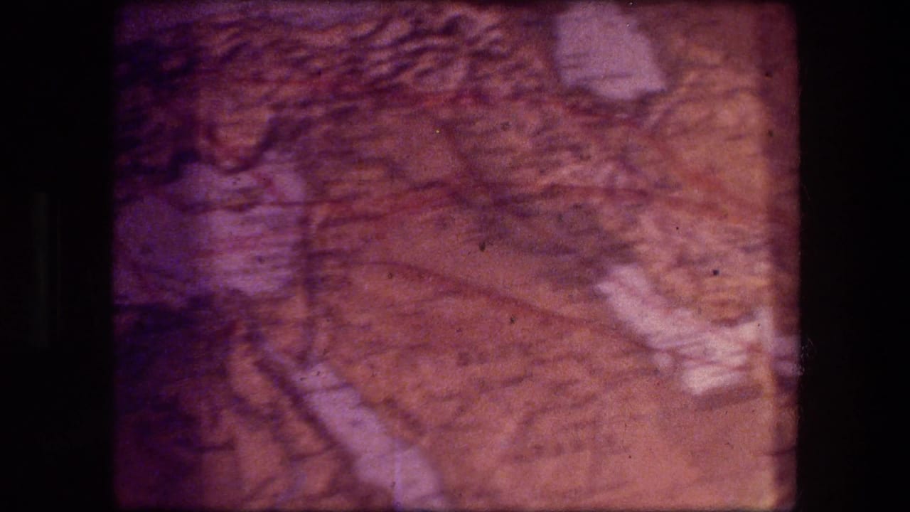 Aged 8mm frame of a printed map, likely from the Jericho travel context, showing highlighted areas and softened cartographic detail.