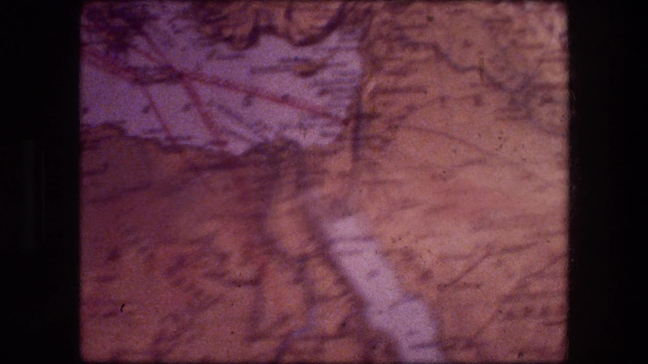 1976 8mm Jericho travel footage showing a soft, faded map-like surface with purple-brown color shift and visible film frame edges.