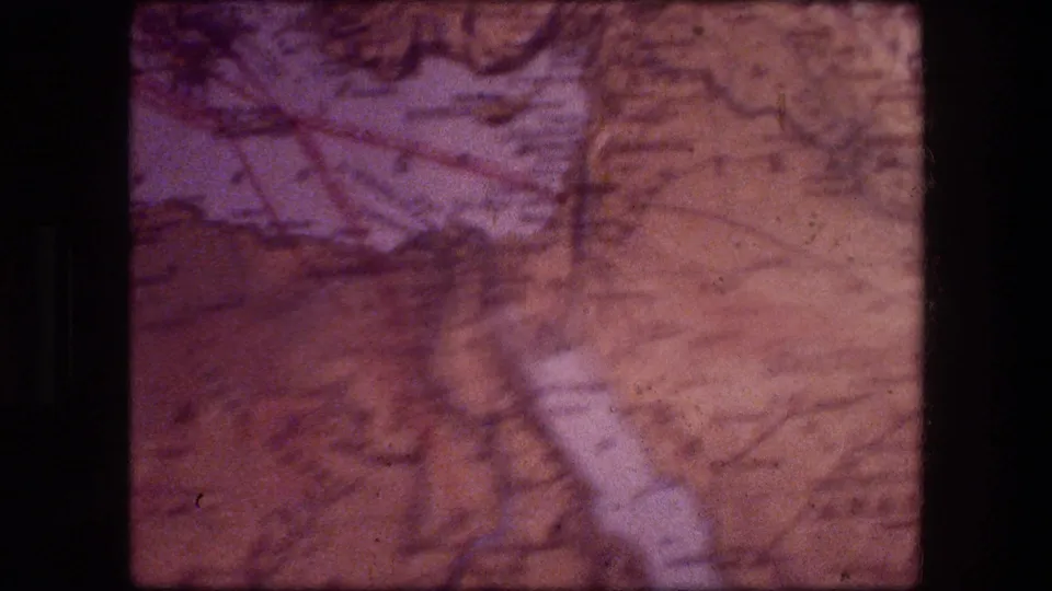 1976 8mm Jericho travel footage showing a soft, faded map-like surface with purple-brown color shift and visible film frame edges.