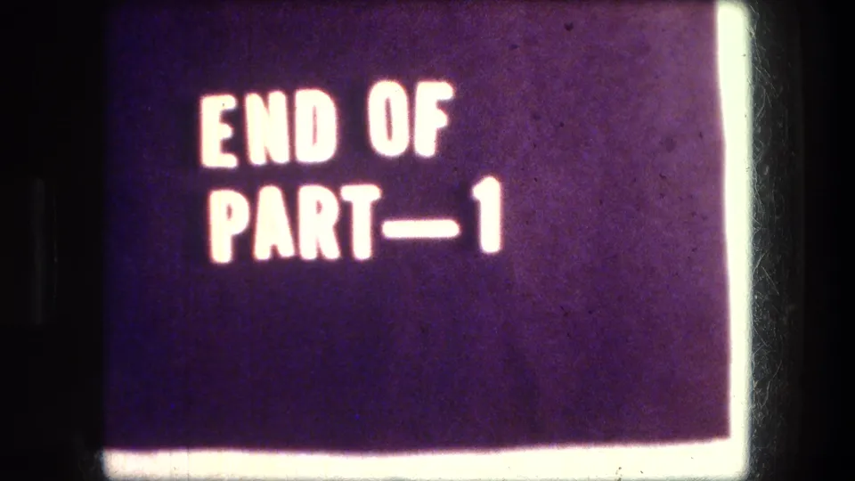 1976 8mm frame showing a deep purple title card with white END OF PART—1 lettering and a bright vertical frame-edge flare.