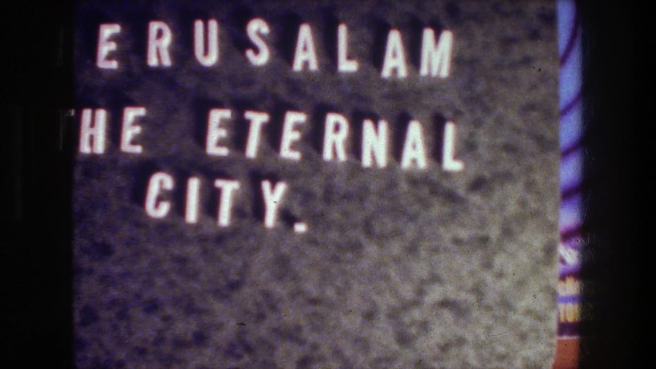 8mm frame of the Jerusalem title card, showing white letters, dark surface texture, grain, and a purple edge tint.