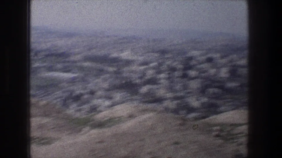 A softer late-frame view from the Jerusalem overlook, with rolling terrain and distant buildings partly blurred by camera movement or focus.