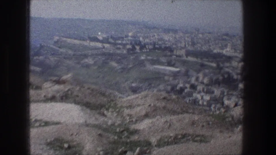 The final frame shows Jerusalem in the distance across dry, uneven hills, with muted color and soft home-movie focus.