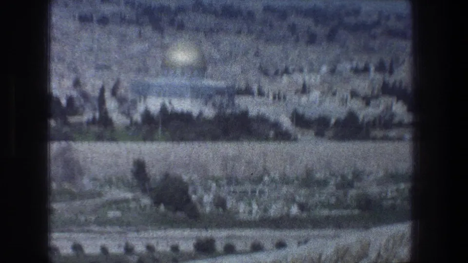 1976 Jerusalem view with the Dome of the Rock visible above dense hillside buildings and trees.