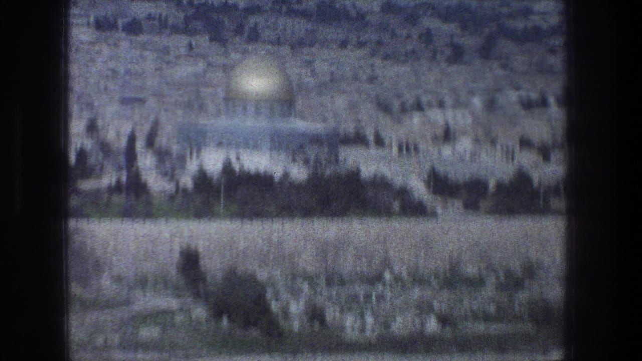 1976 8mm Jerusalem view with the Dome of the Rock, pale stone walls, trees, and a hazy city backdrop.