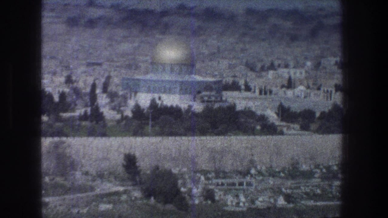 Dome of the Rock and surrounding Jerusalem landscape seen across trees and walls.