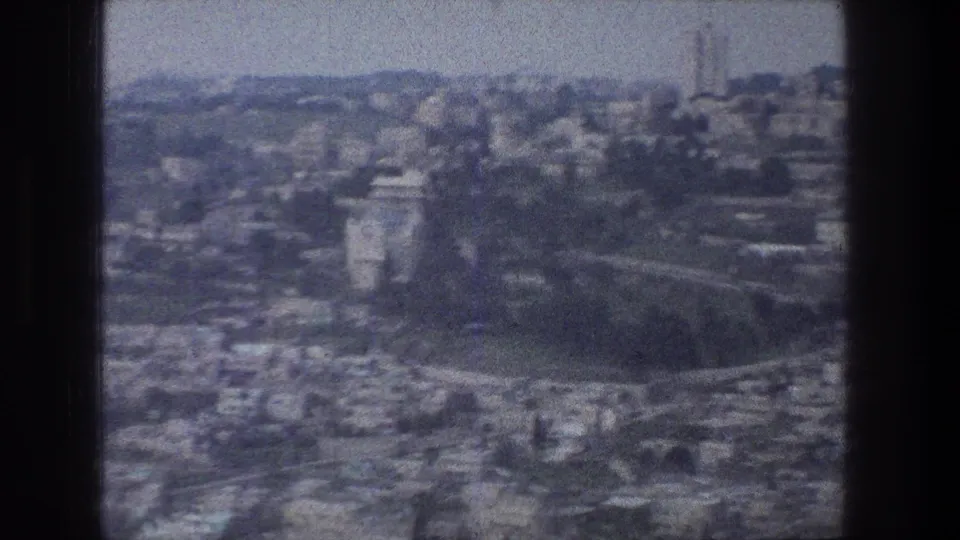 Soft 8mm Jerusalem skyline view from an elevated position, with the camel mostly out of frame at right.
