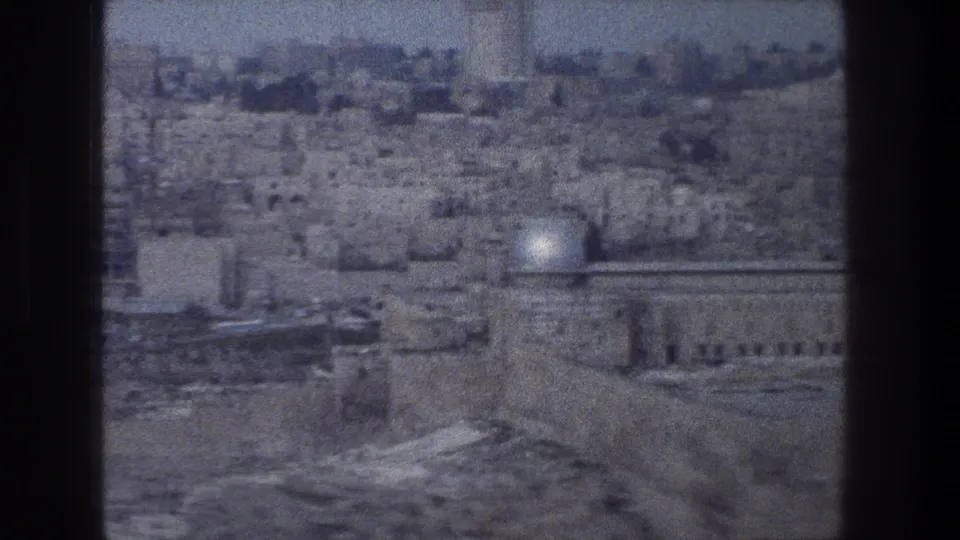 1976 8mm view over Jerusalem’s stone cityscape, with the Dome of the Rock visible in the distance.
